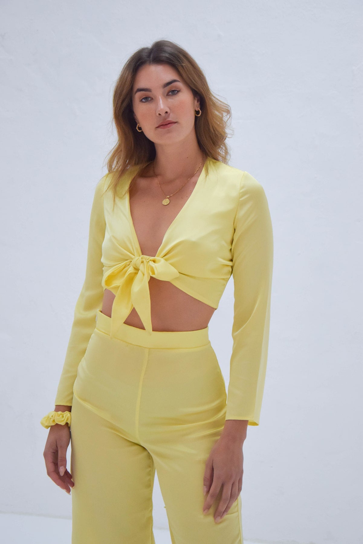 Blusa satinada amarillo pastel con nudo delante