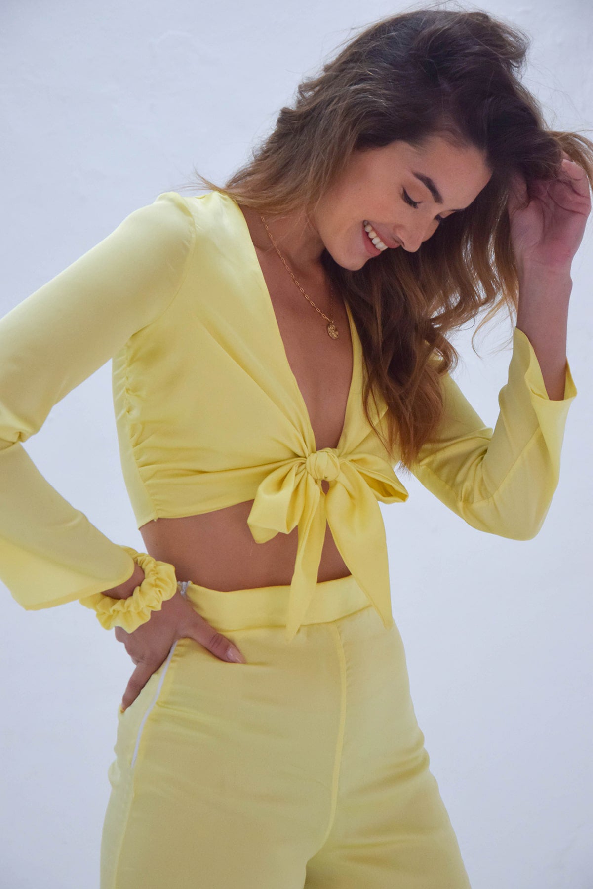 Blusa satinada amarillo pastel con nudo delante